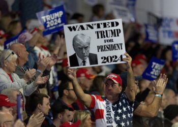 Υποστηρικτής του Ντόναλντ Τραμπ κρατά πανό που αναγράφει «Καταζητείται ο Τραμπ για πρόεδρος το 2024», σε προεκλογική εκδήλωση του πρώην Αμερικανού προέδρου για το χρίσμα των Ρεπουμπλικάνων στις επερχόμενες αμερικανικές εκλογές (φωτ.: EPA/Randall Hill)