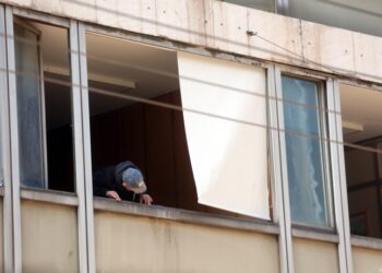 Άνδρας της Αντιτρομοκρατικής ελέγχει τα σπασμένα παράθυρα στο υπουργείο Εργασίας στην οδό Σταδίου(φωτ.: ΑΠΕ-ΜΠΕ/Αλέξανδρος Μπελτές)