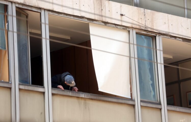 Άνδρας της Αντιτρομοκρατικής ελέγχει τα σπασμένα παράθυρα στο υπουργείο Εργασίας στην οδό Σταδίου(φωτ.: ΑΠΕ-ΜΠΕ/Αλέξανδρος Μπελτές)