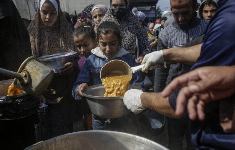 Εκτοπισμένοι Παλαιστίνιοι παίρνουν φαγητό στο συσσίτιο από Άραβες και Παλαιστίνιους δωρητές στη νότια Γάζα (φωτ.: EPA/Mohammed Saber)