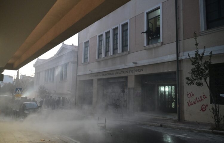 Στιγμιότυπο από τα επεισόδια έξω από τη Νομική Σχολή. Στο παράθυρο επάνω δεξιά διακρίνονται οι κουκουλοφόροι που πετούν πέτρες και μολότοφ στους αστυνομικούς (φωτ.: EUROKINISSI/Τατιάνα Μπόλαρη)
