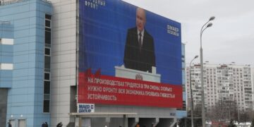 Ρώσοι πολίτες παρακολουθούν σε ζωντανή μετάδοση το διάγγελμα του Βλαντίμιρ Πούτιν σε γιγαντοοθόνη στη Μόσχα (φωτ.: EPA/Maxim Shipenkov)