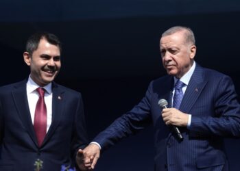 O τούρκος πρόεδρος Ρετζέπ Ταγίπ Ερντογάν κρατά το χέρι του υποψηφίου δημάρχου του κόμματός του για την Κωνσταντινούπολη Μουράτ Κουρούμ σε προεκλογική συγκέντρωση στην οποία όχι μόνο παραβρέθηκε αλλά και κεντρικός ομιλητής (φωτ.: EPA/Erdem Sahin)