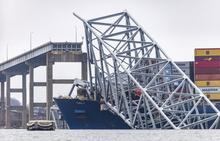 Συντρίμμια από τη γέφυρα φαίνονται δίπλα στην πλώρη του πλοίου το οποίο γκρέμισε τον πυλώνα της, με αποτέλεσμα αυτή να καταρρεύσει, παρασέρνοντας στο θάνατο έξι ανθρώπους (φωτ.: . EPA/Jim Lo Scalzo)