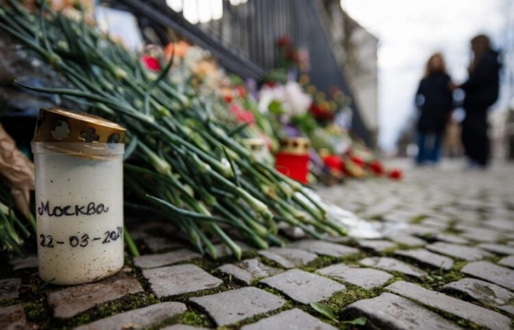 Ένα κερί που γράφει «Μόσχα 22-03-2024» δίπλα σε πλήθος λουλουδιών έξω από τη ρωσική πρεσβεία στο Βερολίνο, στη μνήμη των θυμάτων της επίθεσης (φωτ.: EPA/Clemens Bilan)