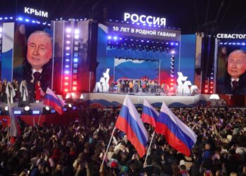 Ο Ρώσος πρόεδρος Βλαντίμιρ Πούτιν διακρίνεται σε γιγαντοοθόνες, στη διάρκεια εορτασμών για τη δέκατη επέτειο προσάρτησης της Κριμαίας στη Ρωσία, μία ημέρα μετά τη λήξη των εκλογών στη χώρα και την επανεκλογή του, η οποία αμφισβητείται ανοιχτά από τη Δύση (φωτ.: EPA/Sergei Ilnitsky)