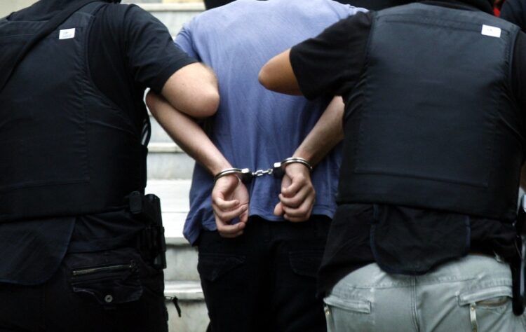 Κρατούμενος φορά χειροπέδες ενώ συνοδεύεται από αστυνομικούς (φωτ.: EUROKINISSI)