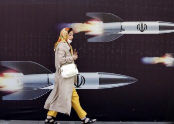 Ιρανή περπατάει μπροστά από τεράστιο αντιισραηλινό μπάνερ που απεικονίζει πυραύλους, στην Τεχεράνη (φωτ.: 
EPA/Abedin Taherkenareh)