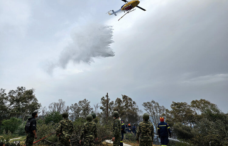 Πυροσβεστικό ελικόπτερο και πυροσβέστες με τη συνδρομή στρατιωτών επιχειρούν για την κατάσβεση πυρκαγιάς που εκδηλώθηκε κοντά στον Ναύσταθμο Χανίων (φωτ.: ΑΠΕ-ΜΠΕ / Πέτρος Παττακός)
