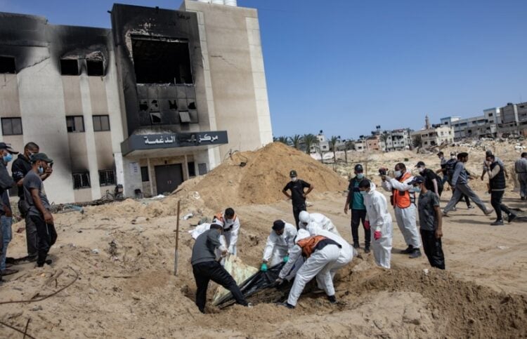 Μέλη της Παλαιστινιακής Πολιτικής Άμυνας ανασύρουν 50 σορούς από έναν μαζικό τάφο στο νοσοκομείο Νασέρ, στην Χαν Γιουνίς, στη Γάζα (φωτ.: EPA/Haitham Imad)