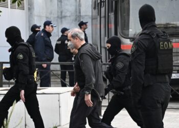 Ο Ηλίας Μίχος (κέντρο) μεταφέρεται στο δικαστήριο συνοδεία αστυνομικών (φωτ.: EUROKINISSI/Κώστας Τζούμας)