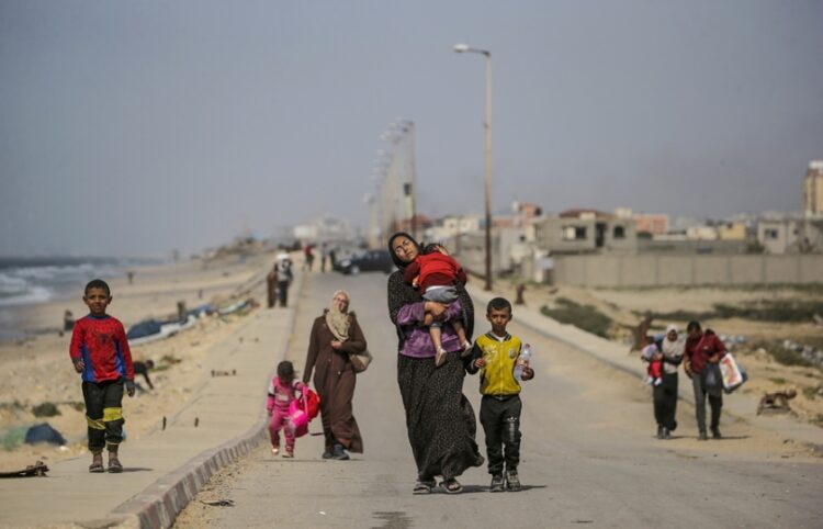 Παλαιστίνιες με τα παιδιά τους διασχίζουν τα βόρεια τμήματα της Γάζας προς το νότο, σε μια προσπάθεια να γλιτώσουν από τα ισραηλινά πλήγματα (φωτ.: EPA/Mohammed Saber)