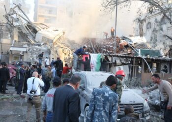 Διασώστες ερευνούν για επιζώντες μετά το ισραηλινό χτύπημα στο προξενείο του Ιράν στη Δαμασκό, το οποίο υπέστη ζημιές. Το διπλανό κτήριο όμως καταστράφηκε ολοσχερώς (φωτ.: EPA/Youssef Dafawwi)
