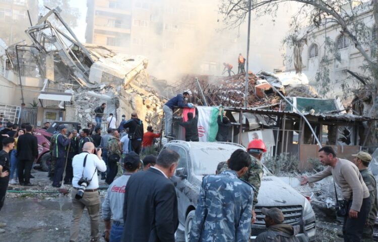 Διασώστες ερευνούν για επιζώντες μετά το ισραηλινό χτύπημα στο προξενείο του Ιράν στη Δαμασκό, το οποίο υπέστη ζημιές. Το διπλανό κτήριο όμως καταστράφηκε ολοσχερώς (φωτ.: EPA/Youssef Dafawwi)