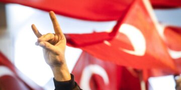 Άνδρας κάνει το σήμα των «Γκρίζων Λύκων» σε παλιότερη διαδήλωση της οργάνωσης, με φόντο τουρκικές σημαίες (φωτ.: EPA/Bas Czerwinski)