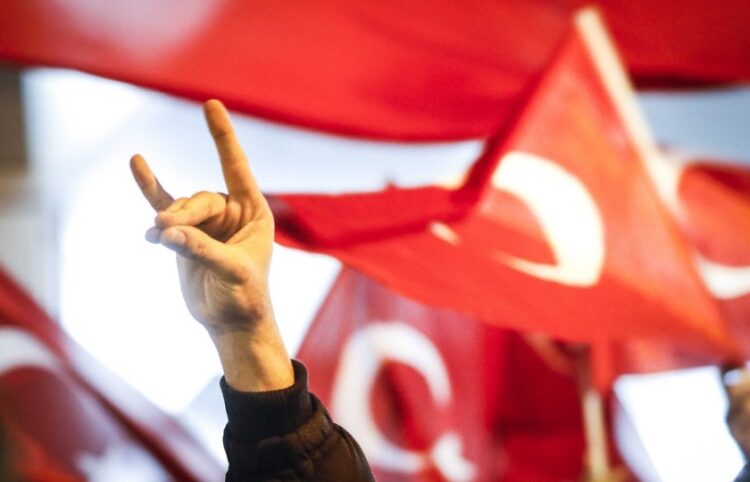 Άνδρας κάνει το σήμα των «Γκρίζων Λύκων» σε παλιότερη διαδήλωση της οργάνωσης, με φόντο τουρκικές σημαίες (φωτ.: EPA/Bas Czerwinski)
