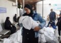 Παλαιστίνια αγκαλιάζει ένα νεκρό παιδί, θύμα ισραηλινών βομβαρδισμών, σε νοσοκομείο της Ράφα (φωτ.: EPA/Haitham Imad)