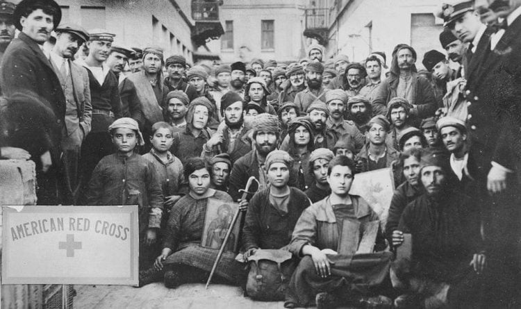 Πρόσφυγες από τη Σμύρνη, μάλλον φωτογραφημένοι στην Ελλάδα όπου έφθασαν με βάρκα.
Φορούν ρούχα που τους έδωσε ο Ερυθρός Σταυρός και κρατούν εικόνες (φωτ.: Library of Congress)