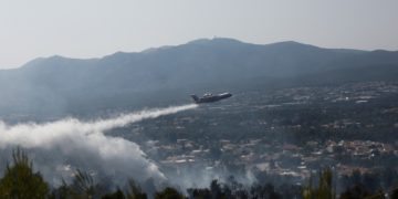 Πυροσβεστικό αεροσκάφος πραγματοποιεί ρίψεις νερού πάνω από κατοικημένη περιοχή κατά τη διάρκεια κατάσβεσης της πυρκαγιάς που ξέσπασε σε δασική περιοχή στη Σταμάτα, Αττικής (φωτ.: ΑΠΕ-ΜΠΕ/ ΓΙΑΝΝΗΣ ΚΟΛΕΣΙΔΗΣ)