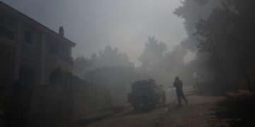 Πυροσβέστης μέσα σε κατοικημένη περιοχή επιχειρεί στην κατάσβεση της πυρκαγιάς που ξέσπασε σε δασική περιοχή στη Σταμάτα, Αττικής (φωτ.: ΑΠΕ-ΜΠΕ / Γιάννης Κολεσίδης)