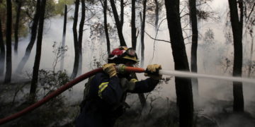 Πυροσβέστης παλεύει με τις φλόγες στη Βαρυμπόμπη, 5/8/2021, (φωτ.: EPA/ Kostas Tsironis)