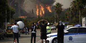 Πολίτες και αστυνομικοί παρακολοθούν από μακρυά τις φλόγες από τη φωτιά που ξέσπασε, σήμερα, σε δασική έκταση στη Βαρυμπόμπη
(φωτ.: ΑΠΕ-ΜΠΕ / Γιάννης Κολεσίδης)