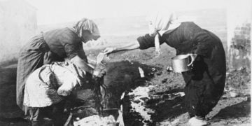 Γυναίκες λούζουν παιδί, το 1922. Η φωτογραφία αποτελεί μέρος συλλογής του Αμερικανικού Ερυθρού Σταυρού και προέρχεται από τη Βιβλιοθήκη του Κογκρέσου. Σύμφωνα με ιστορικές μαρτυρίες, πολλά κορίτσια και γυναίκες έσπευσαν να λουστούν όταν έφτασαν στην Καλαμαριά, μήπως και αποφύγουν το υποχρεωτικό κούρεμα στα Απολυμαντήρια