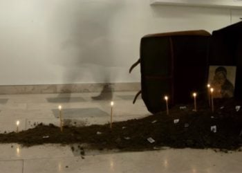 Εγκατάσταση χώμα, βαλίτσα, κεριά, εικόνα, γραμματόσημα, διαστάσεις μεταβλητές. Το 2019 στο Ελληνικό Γενικό Προξενείο της Νέας Υόρκης. Έργο και φωτογραφία του Γιώργου Ταξίδη