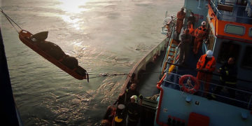 Οι άντρες της ΕΜΑΚ μεταφέρουν την απανθρακωμένη σορό (φωτ.: Πυροσβεστική Υπηρεσία)