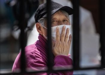 Κάτοικος της Σανγκάης που βρίσκεται πίσω από φράχτη, σε κατοικημένη περιοχή της Κίνας, εν μέσω καραντίνας. (φωτ. αρχείου: ΕΡA/ Alex Plavevski)