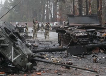 Ουκρανοί στρατιώτες περπατούν ανάμεσα σε κατεστραμμένα ρωσικά άρματα, σε περιοχή που ανακατέλαβαν, πλησίον του Κιέβου (EPA/ SERGEY DOLZHENKO)