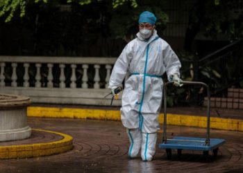 Μέλος των Αρχών της Σαγκάης σε δρόμο της πόλης (φωτ.: EPA/ Alex Plavevski)