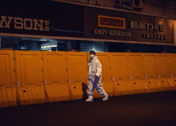 Ένας άνδρας με προστατευτική στολή περπατά μπροστά από απομονωμένη περιοχή (φωτ. αρχείου: EPA/ Alex Plaveski)