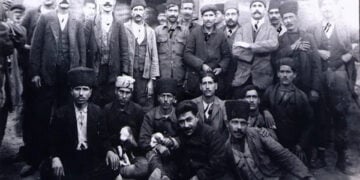 Ανάμεσα στους εικονιζόμενους, στην κάτω σειρά, σημειωμένος με τον δυσδιάκριτο αριθμό 15, με το παλτό και το μουστάκι, βρίσκεται και ο Ηλίας Μέλος, ο μετέπειτα συγγραφέας Ηλίας Βενέζης (φωτ.: Σύλλογος Μικρασιατών Σκάλας Λουτρών «Το δελφίνι»)