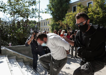 Αστυνομικός οδηγεί στον εισαγγελέα εκτέλεσης ποινών τον 42χρονο που συνελήφθη κατηγορούμενος ως «πελάτης» της ανήλικης που εξέδιδε 
ο επιχειρηματίας από τον Κολωνό (φωτ.: EUROKINISSI / Βασίλης Ρεμπάπης)