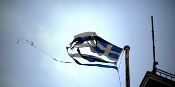 Σκισμένη σημαία κυματίζει από τον αέρα σε κτήριο της Αθήνας (φωτ.: EUROKINISSI / Στέλιος Μισίνας)