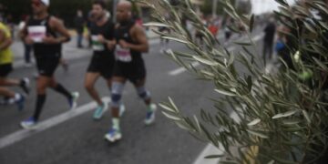 Κλαδί ελιάς δίπλα σε δρομείς που έτρεξαν στον 38ο Αυθεντικό Μαραθώνιο Αθήνας, στην Παλλήνη, το Νοέμβριο 2021 (φωτ.: ΑΠΕ-ΜΠΕ/ΓΙΑΝΝΗΣ ΚΟΛΕΣΙΔΗΣ)