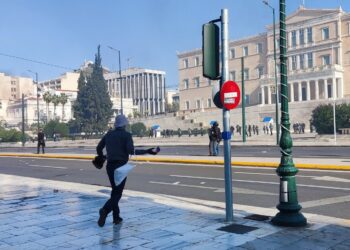 Διαδηλωτής ετοιμάζεται να πετάξει αντικείμενο προς την πλευρά των αστυνομικών που βρίσκονται έξω από τη Βουλή. (Πηγή φωτ.: twitter.com/tony_rgps)