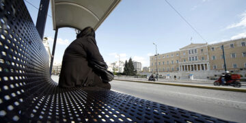 Γυναίκα περιμένει το λεωφορείο σε στάση στην πλατεία Συντάγματος  
(φωτ.: EUROKINISSI / Γιώργος Κονταρίνης)