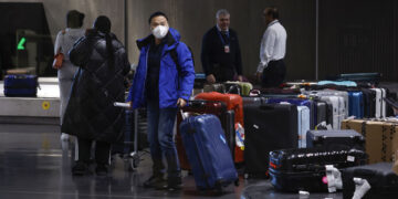 Ταξιδιώτες από την Κίνα στο αεροδρόμιο Ρουασί κοντά στο Παρίσι (φωτ.: EPA / Yoan Valat)