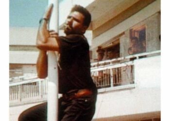 Τηλεοπτικό στιγμιότυπο δείχνει τον Σολωμό Σολωμού να σκαρφαλώνει, για να κατεβάσει την τουρκική σημαία (φωτ. ΑΠΕ-ΜΠΕ)