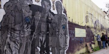 Πολίτες και μέλη της Ομάδας Γειτονιάς του Βαρδάρη καθαρίζουν τοιχογραφία που είναι αφιερωμένη στο Ολοκαύτωμα των Εβραίων στην περιοχή του Νέου Σιδηροδρομικού Σταθμού η οποία βανδαλίστηκε (φωτ.: ΑΠΕ-ΜΠΕ/Αχιλλέας Χήρας)