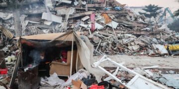 Τούρκοι προσπαθούν να προστατευτούν από το κρύο, ανάμεσα στα συντρίμμια κτηρίου στο Χατάι (φωτ.: EPA/Erdem Sahin)