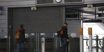 Επιβάτες αγοράζουν εισιτήρια μπροστά από ένα κλειστό σταθμό του προαστιακού σιδηρόδρομου (φωτ.: ΑΠΕ-ΜΠΕ / Γιάννης Κολεσίδης)