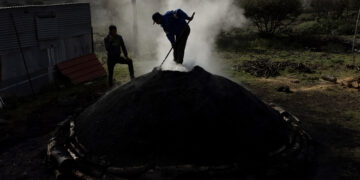 Ο Γιάννης Τυρίκος φροντίζει το καμίνι ώστε να καίγονται σωστά τα ξύλα, στα Μυστεγνά Λέσβου (φωτ.: ΑΠΕ-ΜΠΕ / Ηλίας Μάρκου)