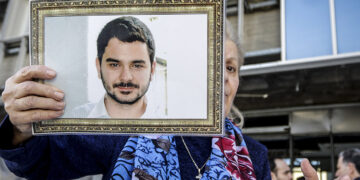 Συγγενής του Μάριου Παπαγεωργίου κρατά τη φωτογραφία του έξω από το  Μικτό Ορκωτό Εφετείο Αθηνών (φωτ.: EUROKINISSI / Γιάννης Παναγόπουλος)