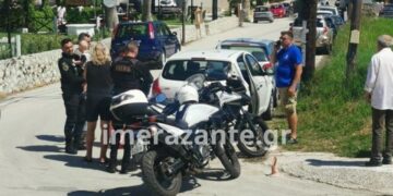 Αστυνομικός διακρίνεται να έχει στην αγκαλιά του το ενός έτους παιδί, το οποίο είχε μείνει μόνο του στο αυτοκίνητο για τουλάχιστον μισή ώρα (φωτ.: Imerazante.gr)