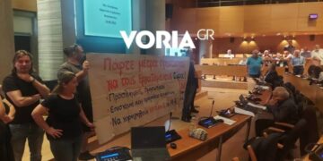 Στιγμιότυπο από την ανάρτηση του πανό στη διάρκεια της συνεδρίασης του δημοτικού συμβουλίου Θεσσαλονίκης (φωτ.: voria.gr)