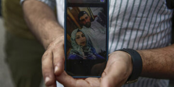 Ο 34χρονος Κασέμ δείχνει τη φωτογραφία της γυναίκας του και του κουνιάδου του, οι οποίοι βρίσκονταν στο πλοίο μαζί με πέντε ακόμα γνωστούς του (φωτ.: ΑΠΕ-ΜΠΕ / Γιάννης Κολεσίδης)