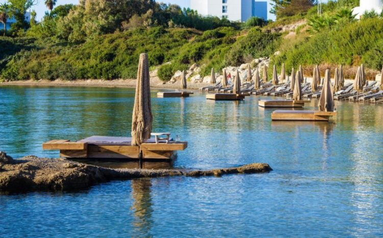 Φωτογραφία όπου διακρίνονται οι κατασκευές εντός της θάλασσας, από τα μέσα κοινωνικής δικτύωσης του beach bar. Αξίζει να σημειωθεί ότι, σύμφωνα με τις δημοσιευμένες φωτογραφίες, οι συγκεκριμένες κατασκευές χρονολογούνται από το 2019, ωστόσο έπρεπε να δημοσιευτεί το βίντεο ενός Βρετανού τουρίστα με τις συνθήκες εργασίας των σερβιτόρων για να παρέμβει το ελληνικό κράτος (φωτ.: facebook/Santa Marina Rhodes)